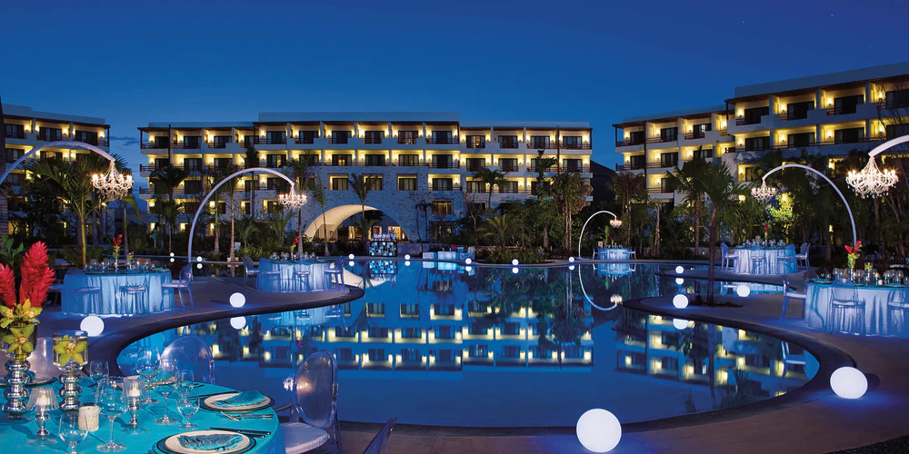 Lagoon Pool nighttime wedding reception setup with illuminated décor at Secrets Akumal Riviera Maya
